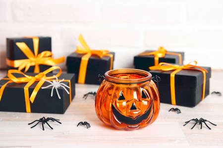 Halloween holiday background with pumpkin Jack lantern candlestick and gifts on a table. Copy space for text.の写真素材