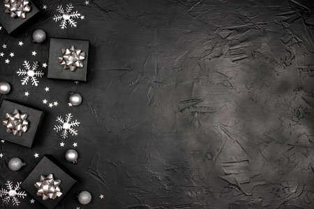 Christmas border made of silver decorations on a black background. Copy space, top view, flat layer.