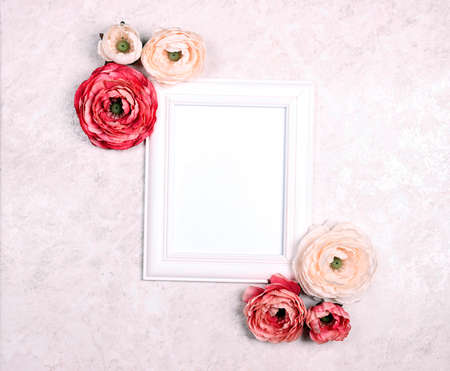 Festive romantic background with empty white frame, peony flowers on light marble. Top down...
