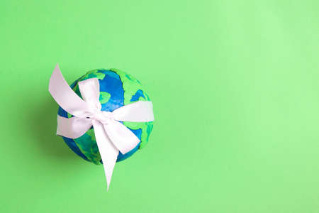 Planet Earth with white on a green background. Copy space for text. Ecology, environmental protection. World Earth Day concept.の写真素材
