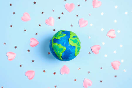 Planet Earth among the stars and hearts on a blue background. Science, ecology, environmental...
