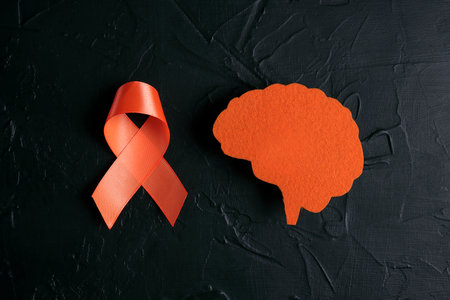 World Multiple Sclerosis Day. Orange awareness ribbon and brain symbol on a black background.の写真素材