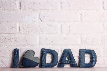 Father's day message from denim letters on the background of a white brick wall. Copy space for text.の写真素材