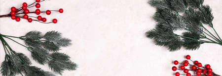 Christmas frame of spruce branches and red berries on light marble background. Christmas, winter,...