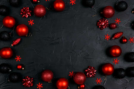 Christmas frame of red ad black decoration on black background. Flat Lay, top view, copy space.の写真素材