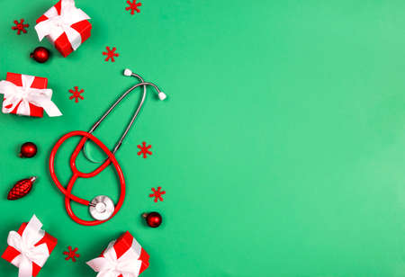 Stethoscope with Christmas decorations on green background. Christmas greeting card for medics concept. Copy space for text.の写真素材