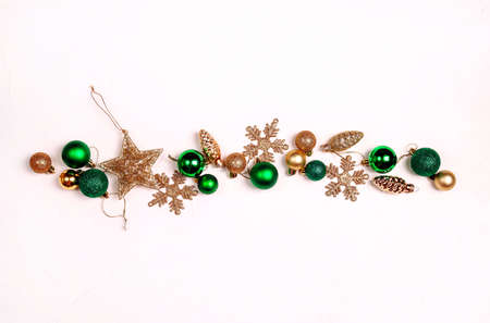 Gold and green Christmas decorations on a white background. Top view, flat layer, copy space for text.の写真素材