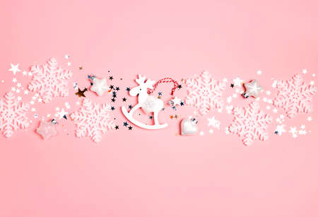 Festive dorder of white decorations on a pink background. Christmas, New Year, winter concept.の写真素材