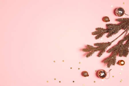 Gold Christmas composition with fir branches and balls on a pink background. Copy space, top view.の写真素材