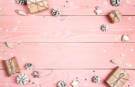 Christmas frame of gifts and decorations on a pink wooden background. Top view, space for text.の写真素材