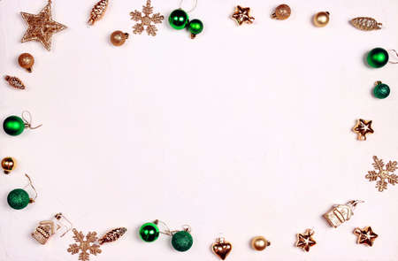 Frame from gold and green Christmas decorations on a white background. Top view, flat layer, copy...