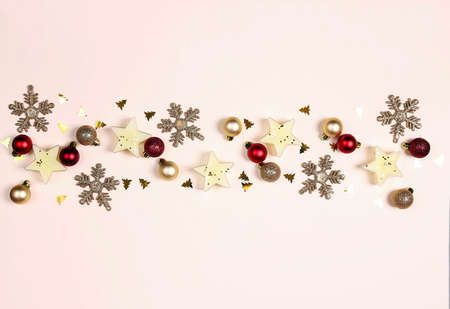 Gold Christmas composition with candles, balls, snowflakes and sparkles on a beige background. Copy...
