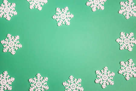 Winter green background with snowflakes. Copy space. Flat lay.の写真素材
