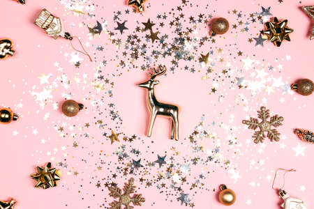 Golden glittering decorations and sparkling sequins on pink background. Festive luxury background.の写真素材