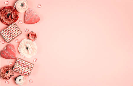 Romantic border of gifts, flowers and decorative hearts on pink background. Place for text, top down...