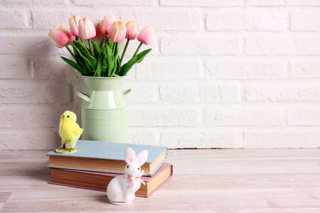 Easter background with books, chicken, rabbit and tulips against a white brick wall. Copy space for text.の写真素材