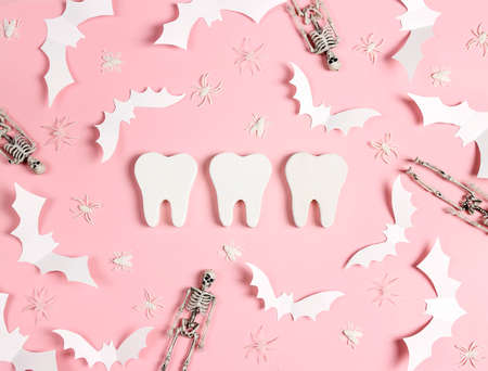 White teeth with Halloween decorations on pink background. Dentist Halloween concept. Top view, flat lay.の写真素材