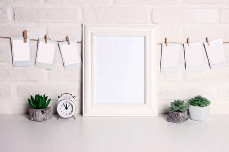 Blank instant photos, photo frame and house plants on white brick wall. Place for your images.の写真素材