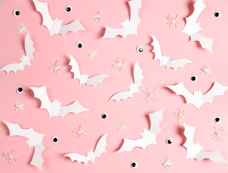 Halloween pink background with white bats, spiders and eyes. Flat lay, top view.の写真素材