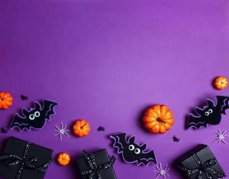 Halloween purple background with black gift, pumpkins, bats and spiders. Flat lay, top view frame with copy space.の写真素材