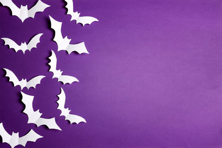 Halloween paper decorations bats on purple background. Flat lay, top view, copy space. Happy halloween banner mockup.の写真素材