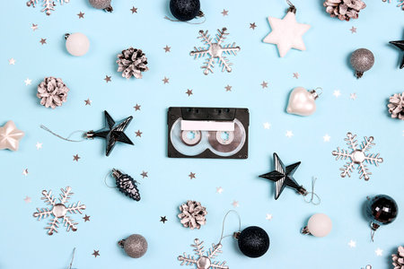 Audio cassette tape with Christmas decorations on blue background. Holiday music for winter mood. Nostalgia concept. Place for song title.の写真素材