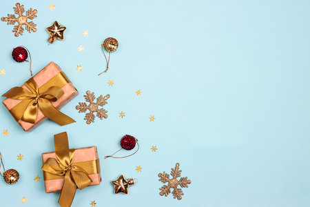 Festive winter border with gifts and golden decorations on a blue background. Flat lay, copy space, top view.の写真素材