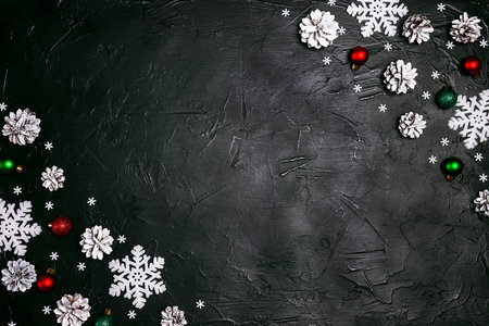 Festive frame with snow painted cones and Christmas decorations on a black background. Christmas, New Year, winter concept with copy space.の写真素材