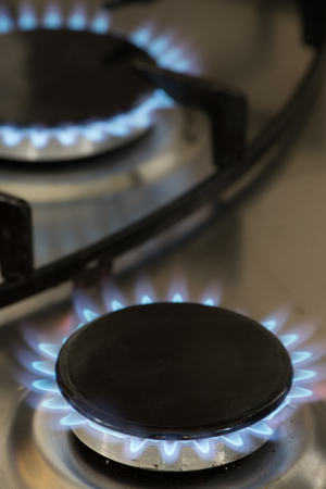 flames burning on a gas stove in the kitchenの写真素材