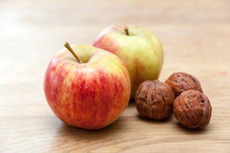 Nuts and apples on wooden tableの写真素材