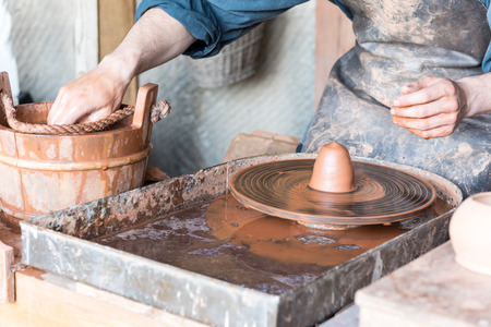 Man making pot on potter wheel in a workshopの写真素材
