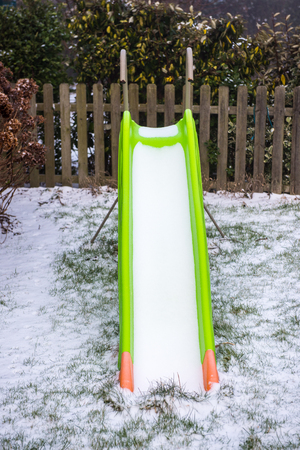 Toboggan covered with snow in a gardenの写真素材