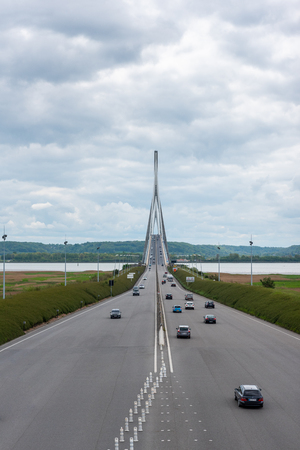 Bridge of Normandy, Le Havre, France - May 04, 2018 : Cars on the highway before the Normandy bridge Bridge of Normandy, Le Havre, France - May 04, 2018 : Cars on the highway before the Normandy bridge