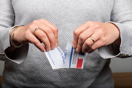 Paris,  France - November 22, 2019 : woman ripping up her voter card