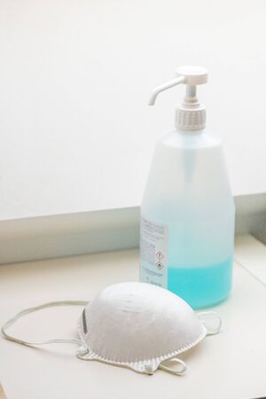White medical mask an gel hydroalcoholic . Face mask and gel hydroalcoholic, protection against pollution, virus, flu and coronavirus. Health care and surgical concept.の写真素材