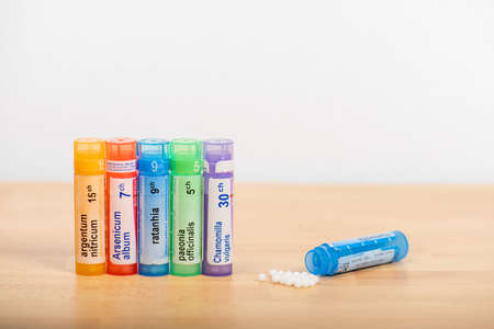 Paris, France - November 27, 2019 : Homeopathic globules scattered around with their colored...