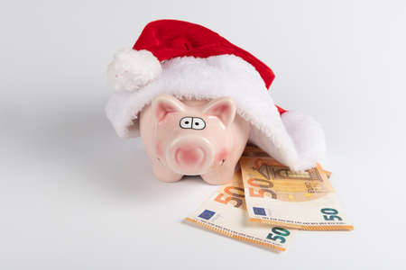 Money and christmas concept: Santa's hat and euro money on white backgroundの写真素材