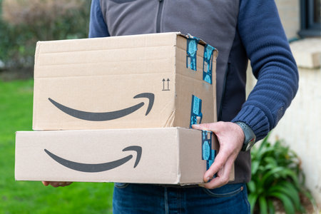 Lille, France - December 18, 2020: Man delivers Amazon Prime package ordered on the amazon site