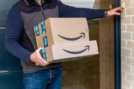 Lille, France - December 18, 2020: Man delivers Amazon Prime package ordered on the amazon siteのeditorial素材