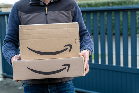 Lille, France - December 18, 2020: Man delivers Amazon Prime package ordered on the amazon site