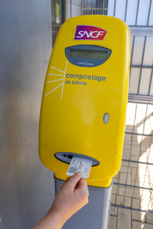 Wingen sur Moder, France - August 08, 2022: Young girl registering a ticket before taking her train...