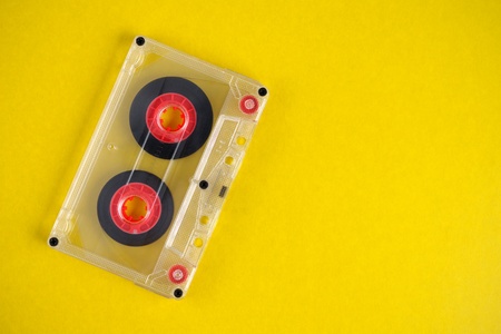 Old audio cassette on yellow background