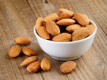 Almonds in bowl on wooden tableの写真素材