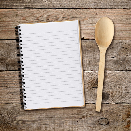 Recipe book and spoon on wooden backgroundの写真素材