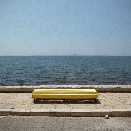 Bench on blue sea background in retro styleの写真素材