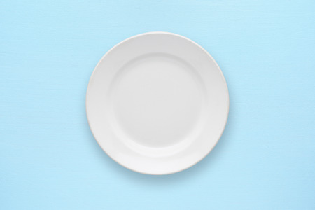White empty plate top view on table