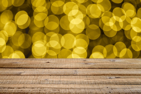 Old wooden table with golden festive bokeh. Shallow depth of fieldの写真素材