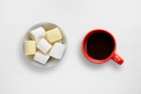 Marshmallow and coffee cup on white tableの写真素材