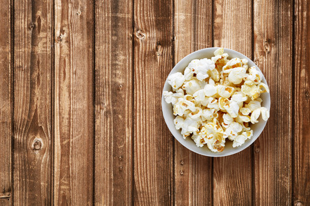 Popcorn in bowl on wooden backgroundの写真素材