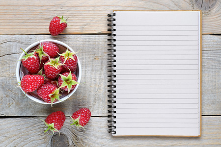 Raspberry and recipe book on wooden tableの写真素材